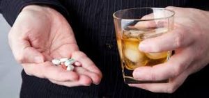 high functioning addict swallows pills with alcohol