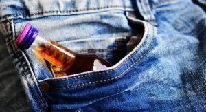 Bottle of alcohol in jeans pocket. Addictions can take over your work life, relationships, and health.